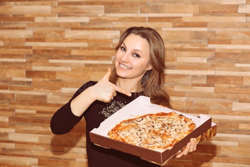 Tevreden vrouw die op pizza richten royalty-vrije stock afbeeldingen Tevreden vrouw die op pizza richten royalty-vrije stock afbeeldingen