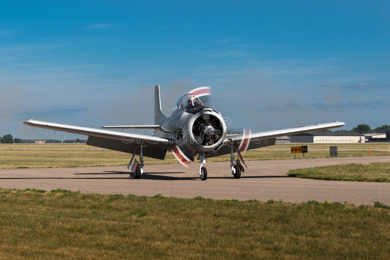 EDEN PRAIRIE, MN - JULY 16 2016: AT-6 Texan airplane makes a turn on the taxiway after landing at air show. The AT-6 Texan was primarily used as trainer aircraft during and after World War II. EDEN PRAIRIE, MN - JULY 16 2016: AT-6 Texan airplane makes a turn on the taxiway after landing at air show. The AT-6 Texan was primarily used as trainer aircraft during and after World War II.