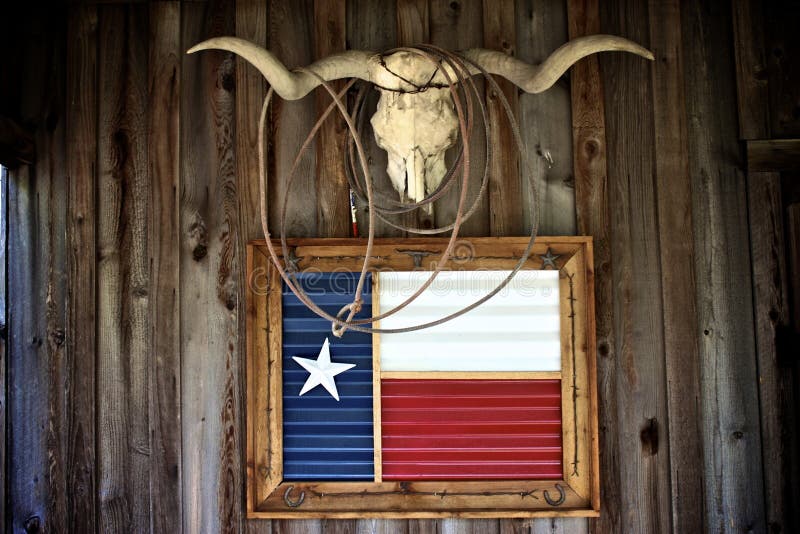 Una vaca cabeza bandera sobre el rancho casa muro.