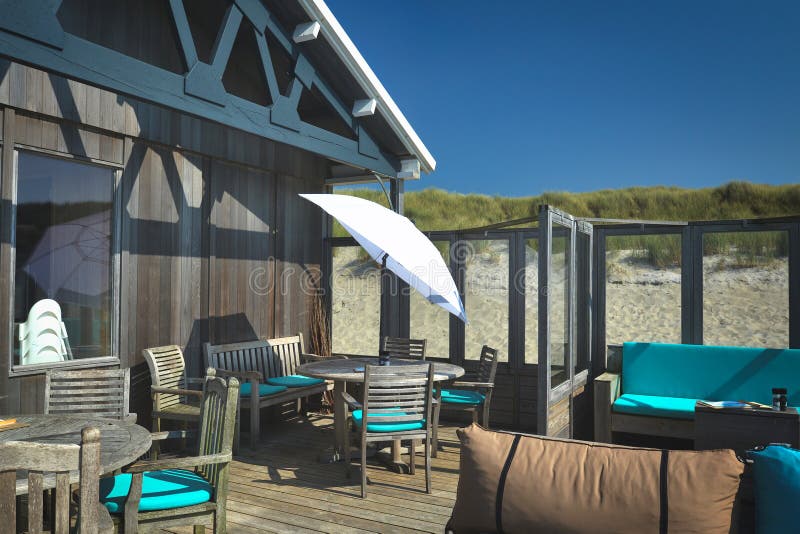 Beautiful rustic wooden and teal colored interior design of `Paal 19` beach pavilion terrace on island Texel on a sunny summer day