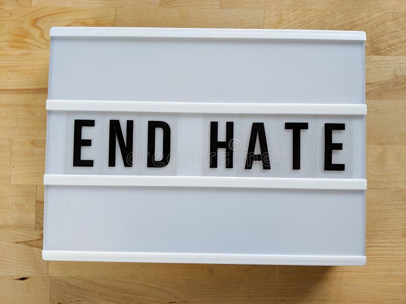 Text in english spelling `End Hate` on a lightbox against wood background stock images Text in english spelling `End Hate` on a lightbox against wood background stock images
