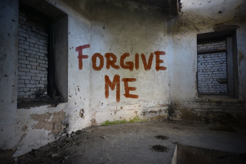 Text forgive me on the dirty old wall in an abandoned house