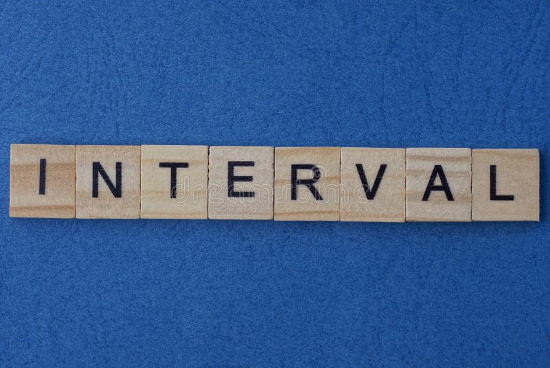 Text on gray word interval of small wooden square letters lies on a blue paper table