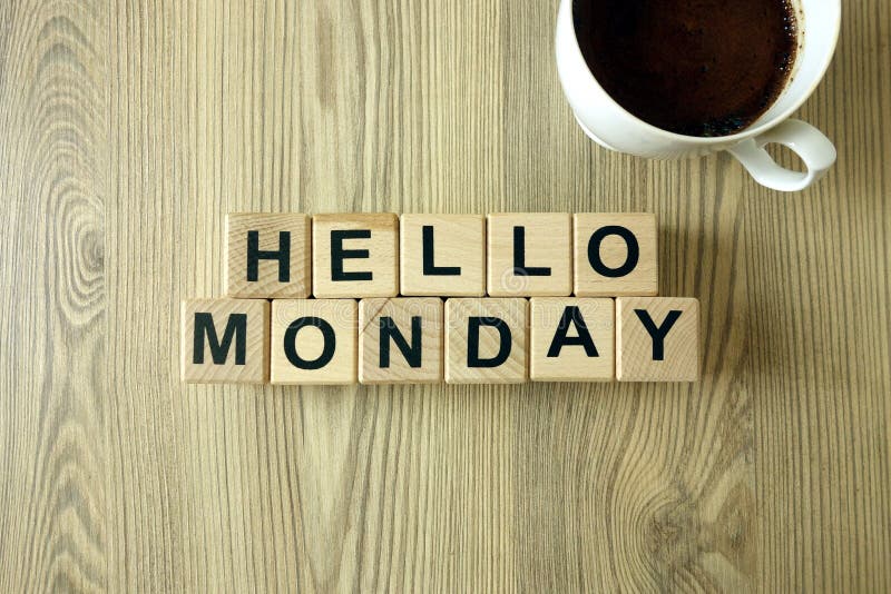 Text hello monday and cup of aromatic coffee on wooden background stock images