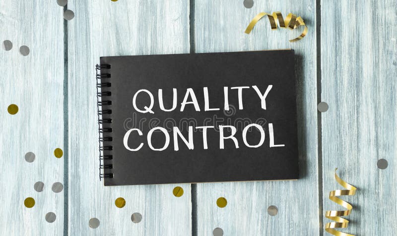Text showing Quality Control on black notepad stock images