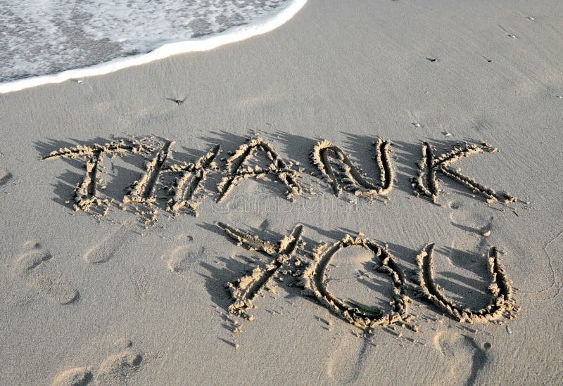 Text THANK YOU written on the sand of the beach