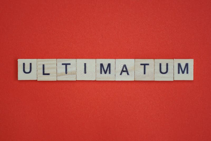 Text the word ultimatum from gray wooden small letters with black font on an red table