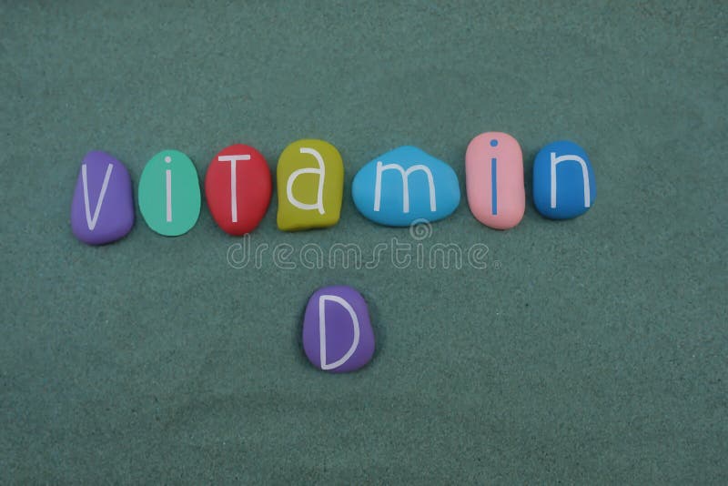 Texte de la vitamine d composé avec les lettres de pierres colorées multiples sur le sable vert illustration stock