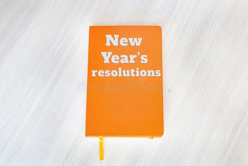 Texte : Résolutions du ` s de nouvelle année concernant la couverture du livre orange sur photographie stock Texte : Résolutions du ` s de nouvelle année concernant la couverture du livre orange sur photographie stock