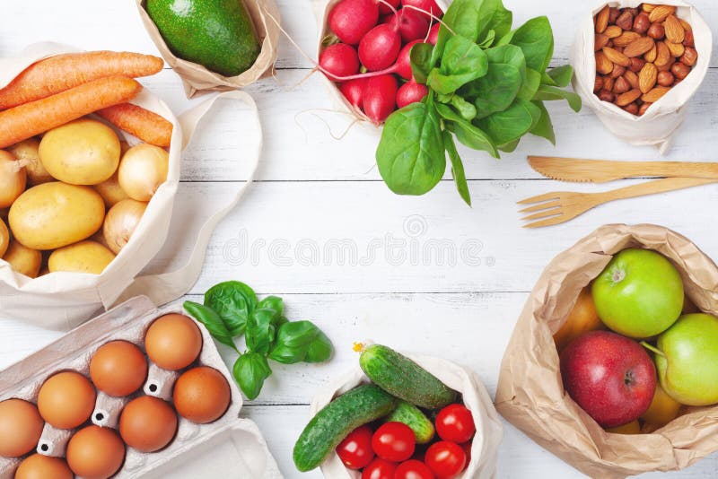 Textile and paper bags with vegetables and fruits and reusable bamboo kitchen utensils top view. Zero waste food shopping, eco friendly and plastic free concept. Textile and paper bags with vegetables and fruits and reusable bamboo kitchen utensils top view. Zero waste food shopping, eco friendly and plastic free concept