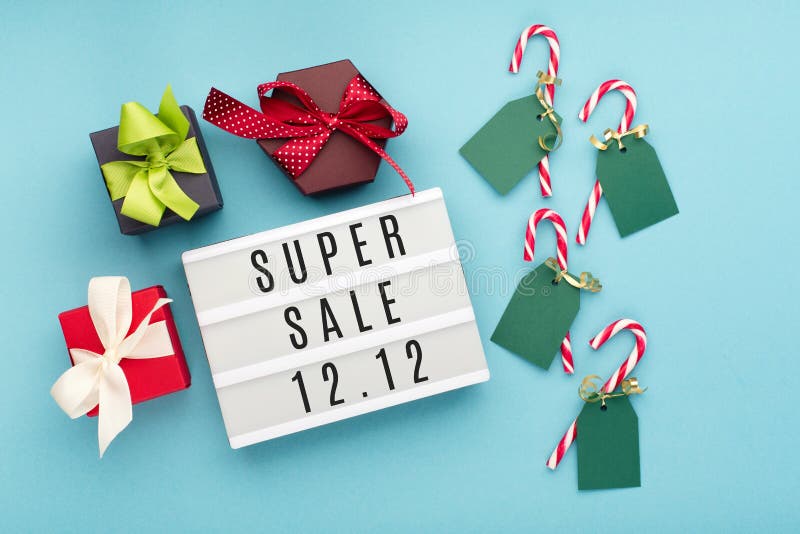 12.12 Super Sale text on white lightbox, with gift boxes and Christmas decorations on blue paper background. Double 12 Mega sales day concept. Top view, flat lay, copy space. 12.12 Super Sale text on white lightbox, with gift boxes and Christmas decorations on blue paper background. Double 12 Mega sales day concept. Top view, flat lay, copy space