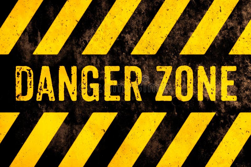 Texto do sinal de aviso da zona de perigo com as listras amarelas e pretas pintadas sobre o fundo da textura do cimento da fachad