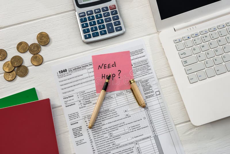 Texto 'Precisa de ajuda' no formulário e no notebook 1040 foto de stock