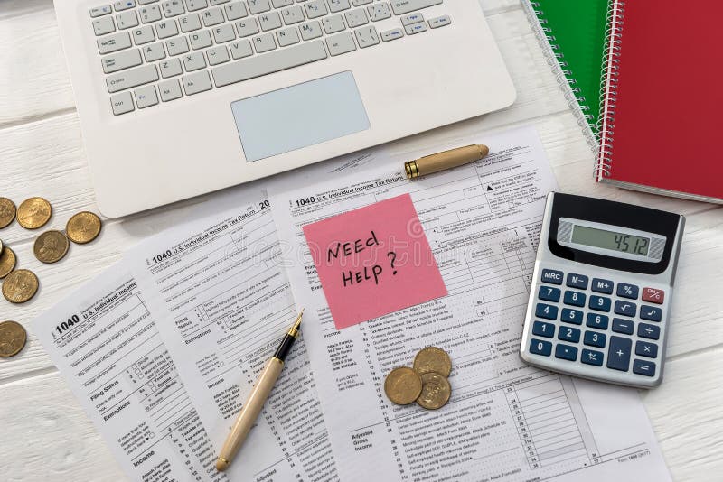 Texto 'Precisa de ajuda' no formulário e no notebook 1040 fotografia de stock