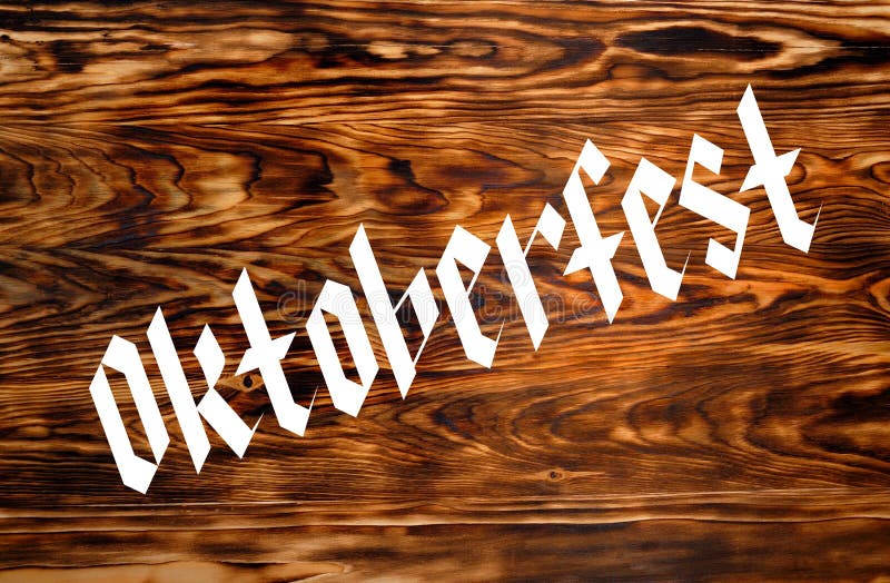 Textur från bränt brunt ved Oktoberfest-inskription arkivfoton