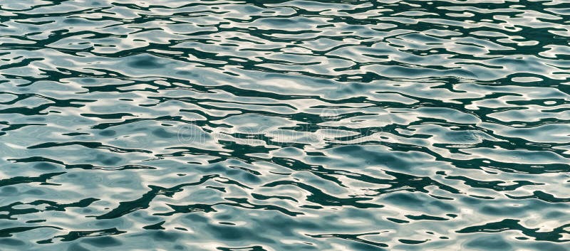Textur för blått vatten, med krusningar och solreflexioner arkivfoto Textur för blått vatten, med krusningar och solreflexioner arkivfoto