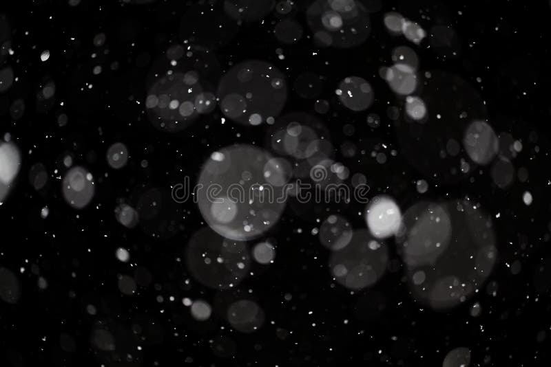 Textura do bokeh da neve no fundo preto imagem de stock royalty free Textura do bokeh da neve no fundo preto imagem de stock royalty free