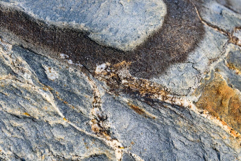 Texture approximative dans la pierre, bleu, gris, orange, et blanc, avec une ligne brune incurv?e, comme fond de nature photographie stock Texture approximative dans la pierre, bleu, gris, orange, et blanc, avec une ligne brune incurv?e, comme fond de nature photographie stock