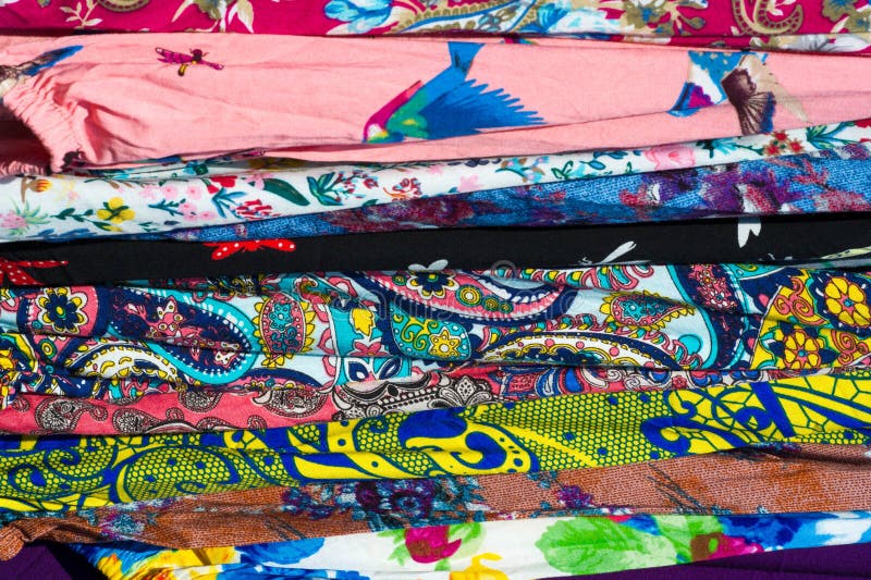 Texture background, pattern. Different fabrics stacked on a table in a pile