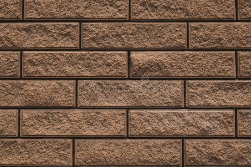 Texture of brown brick wall. The wall is tiled decorative. Stone background of house facade. Brick wall texture grunge background. royalty free stock photography