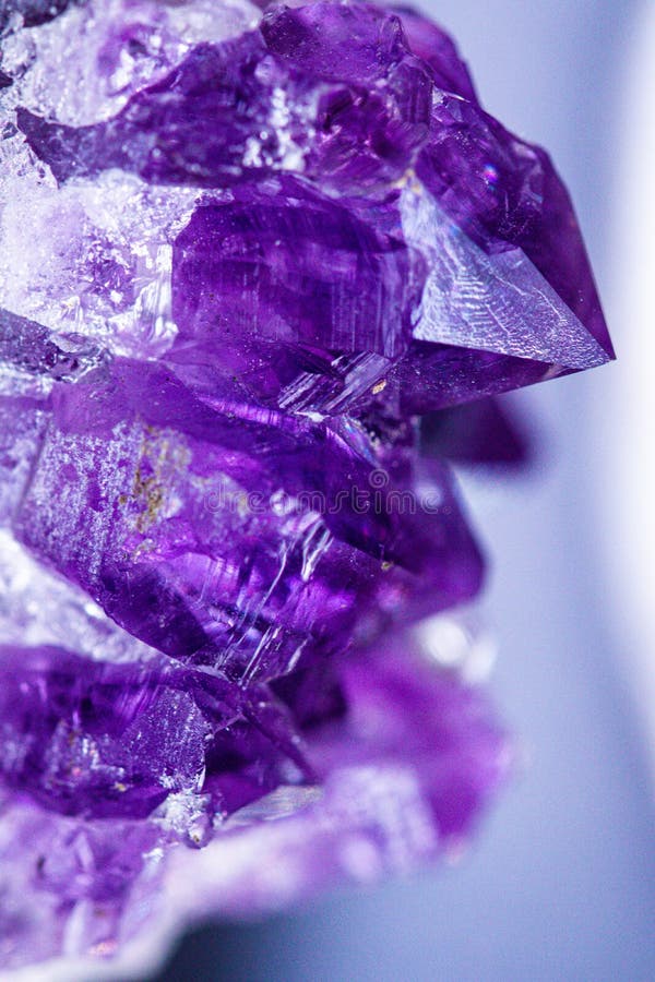 Geology of beauty. Natural healing wild jewels. Texture of gemstone lilac Amethyst closeup as a part of cluster geode filled with rock Quartz crystals.