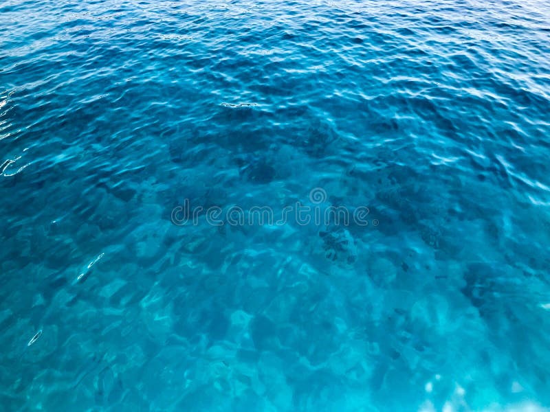 Texture light blue wet beautiful azure transparent sea, ocean water, sea, ocean with small waves, light ripples. The background stock photos Texture light blue wet beautiful azure transparent sea, ocean water, sea, ocean with small waves, light ripples. The background stock photos