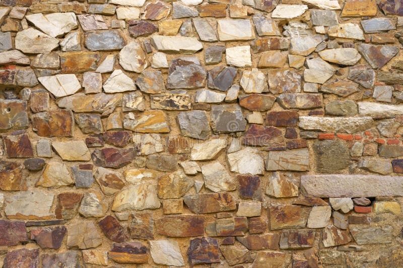 The texture of the old medieval wall of the house, lined with brown stone royalty free stock photo