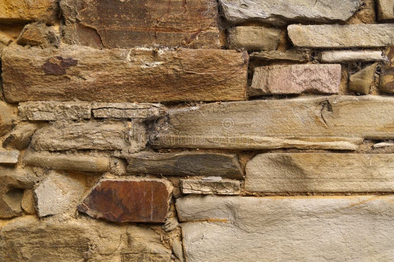 The texture of the old medieval wall of the house, lined with brown stone royalty free stock photos