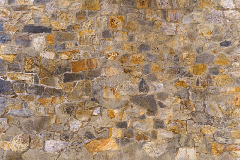 The texture of the old medieval wall of the house, lined with brown stone royalty free stock photography