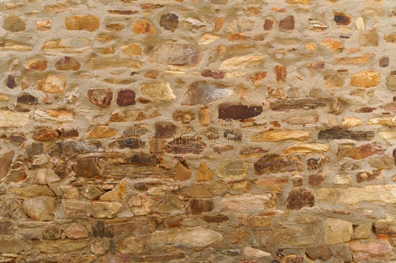 The texture of the old medieval wall of the house, lined with brown stone royalty free stock photos