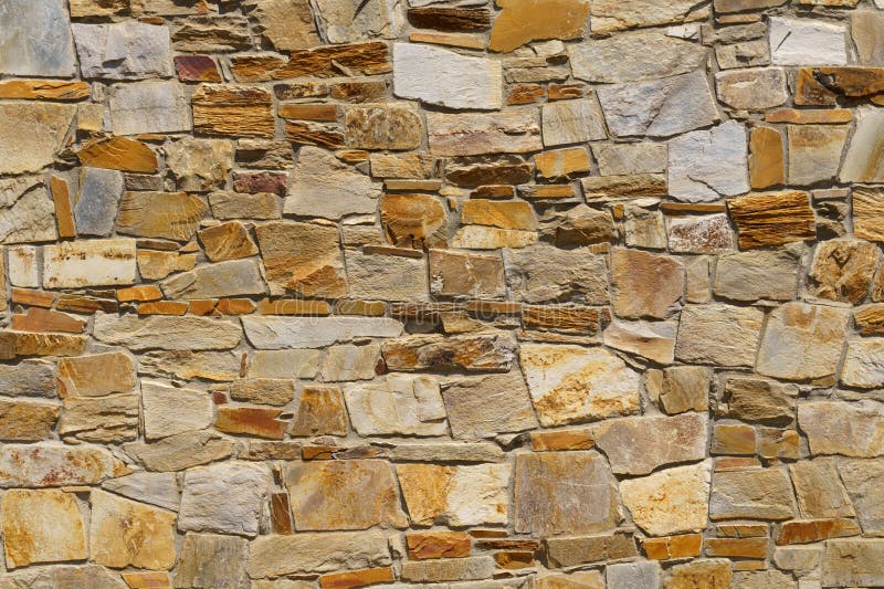 The texture of the old medieval wall of the house, lined with brown stone royalty free stock images
