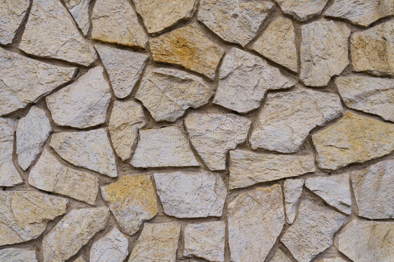 The texture of the old medieval wall of the house, lined with brown stone stock photos