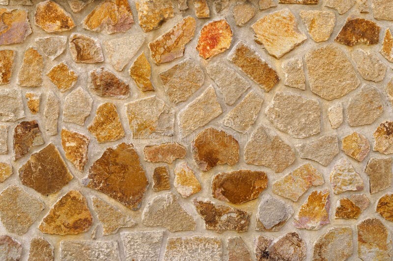 The texture of the old medieval wall of the house, lined with brown stone stock photo
