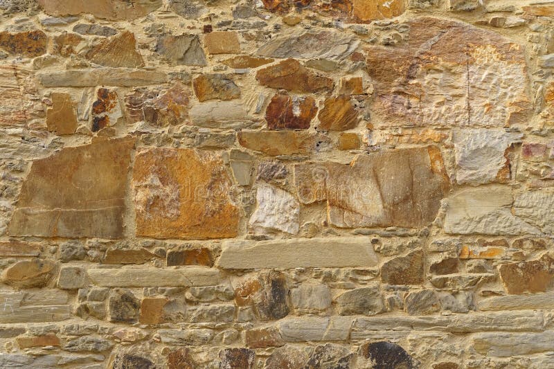 The texture of the old medieval wall of the house, lined with brown stone royalty free stock photography