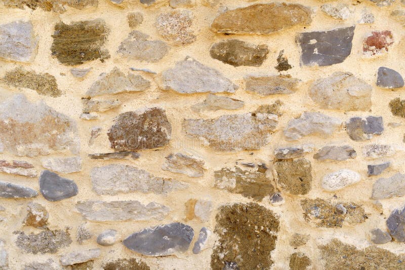 The texture of the old medieval wall of the house, lined with brown stone stock photos