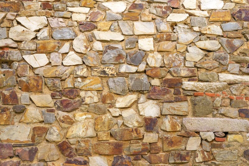 The texture of the old medieval wall of the house, lined with brown stone royalty free stock photography