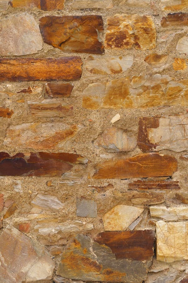 The texture of the old medieval wall of the house, lined with brown stone royalty free stock images