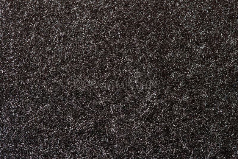Texture of organic black paper for artwork with numerous natural inclusions. Modern dark background, backdrop, substrate royalty free stock images