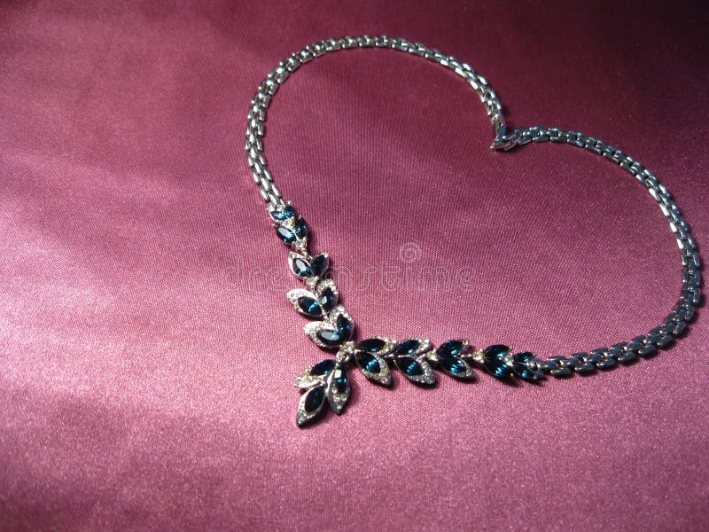 Texture of pink silk with silver necklace and blue gemstones stock image Texture of pink silk with silver necklace and blue gemstones stock image