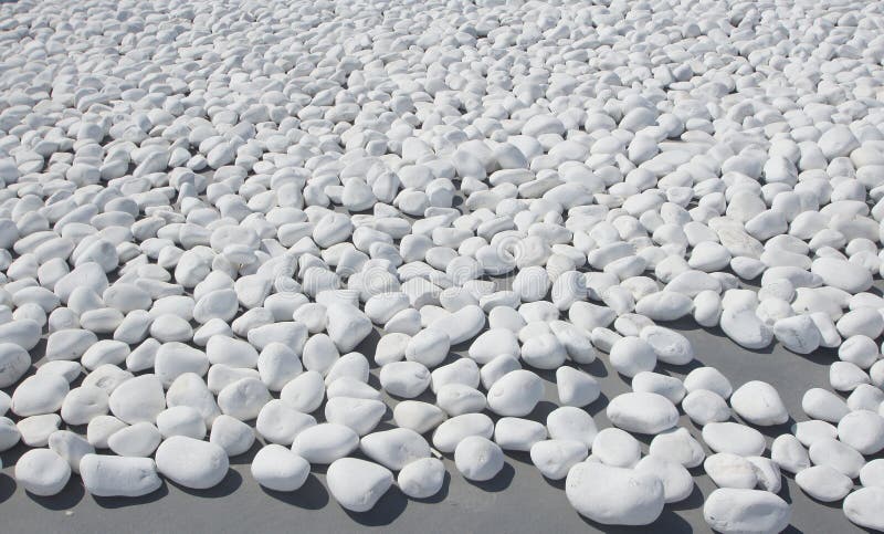 Texture of small, white beach stones on grey