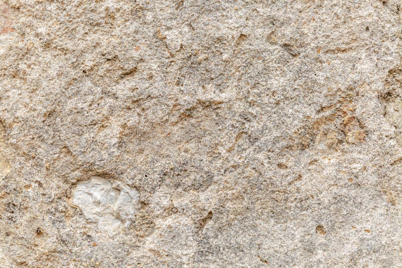 The texture of the surface of natural stone, close-up. Building material of ancient civilizations. Background. Spaces for text