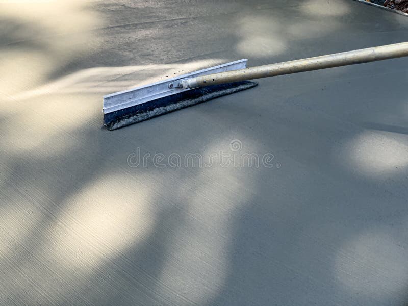 Textured Concrete Broom Brushing a Freshly Poured Surface Stock Photo