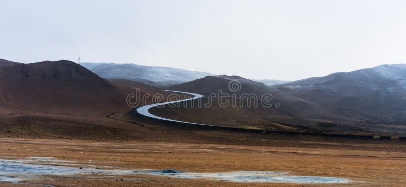 Textured, cracked and patterned ground in the Namaskard/Myvatn area in Icelandic nature. S shaped road and snow covered mountains in the background. Minerals stock images Textured, cracked and patterned ground in the Namaskard/Myvatn area in Icelandic nature. S shaped road and snow covered mountains in the background. Minerals stock images