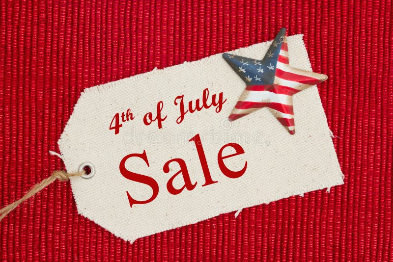 4th of July Sale text on a cloth gift tag with a retro American flag star on shiny red material. 4th of July Sale text on a cloth gift tag with a retro American flag star on shiny red material