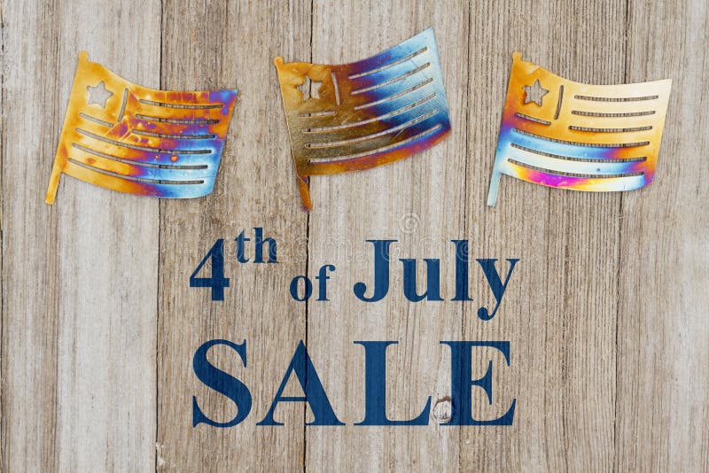 4th of July Sale text with USA patriotic old metal flags on a weathered wood. 4th of July Sale text with USA patriotic old metal flags on a weathered wood