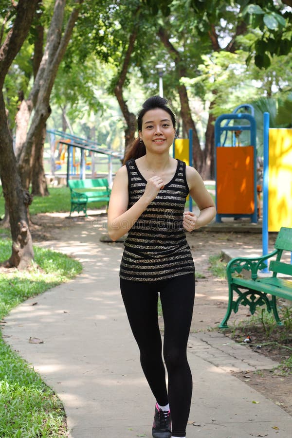 Thai Adult Beautiful Girl Doing Running Exercises In The Park Stock