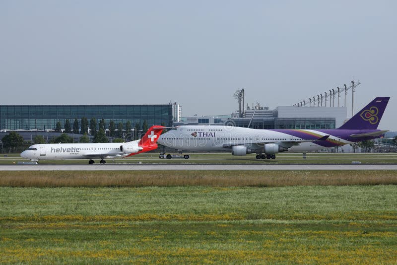 Thai Airways i Helvetic taxiing w Monachium lotnisku, MUC, frontowy widok zdjęcie stock Thai Airways i Helvetic taxiing w Monachium lotnisku, MUC, frontowy widok zdjęcie stock