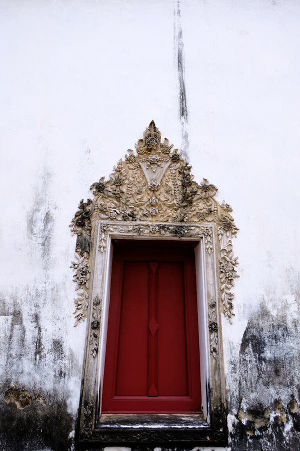 The Thai art stucco of Window frame isolate with white color and red wood color.