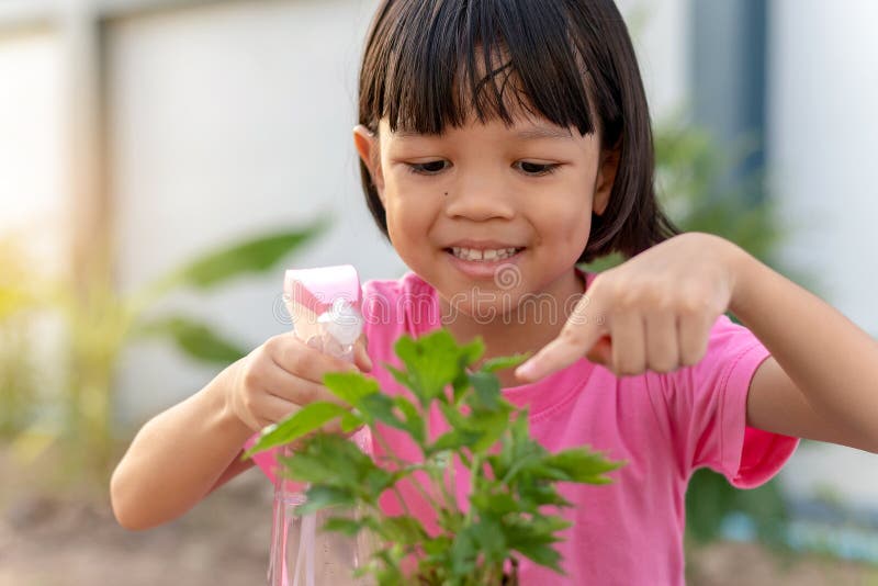 Thai Asian kid girls aged 4 to 6 years old are learning to plant trees. And she is taking care of her plants with love and care.