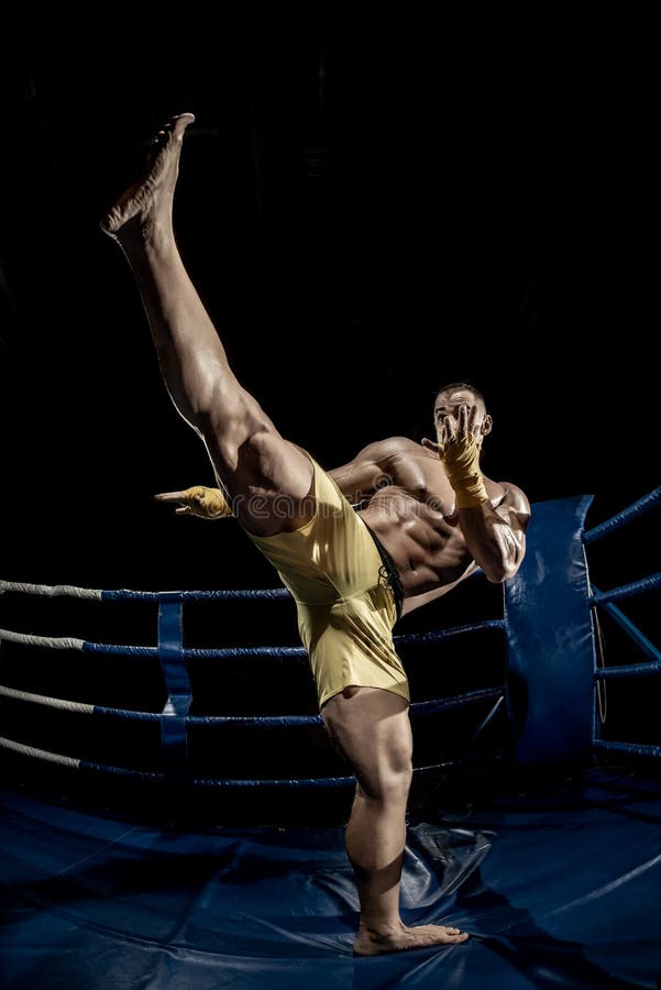 Thai boxer on boxing ring, kicking